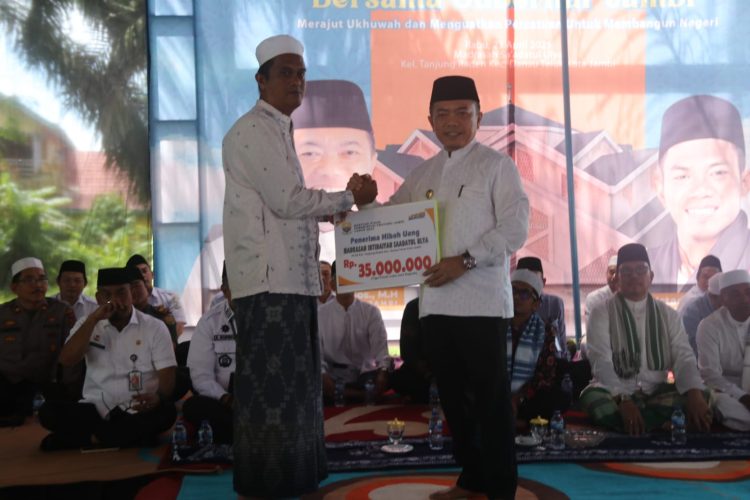 Gubernur Al Haris saat menyerahkan secara simbolis kepada perwakilan Madrasah Ibtidaiyah Sabatul Ulta dalam acara silaturahmi bersama tokoh agama dan masyarakat di Tanjung Raden, Kota Jambi, Rabu (23/4/2025). (dok. Erik Kominfo)