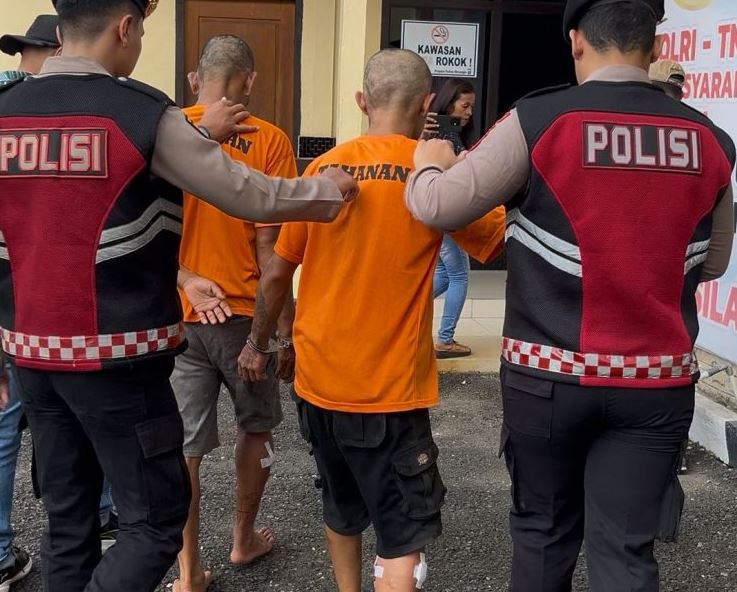 Anggota Polres Merangin menggiring dua tersangka kasus pencurian dengan kekerasan di Desa Sungai Tebal. Sabtu (05/05/2025) (Dok. Humas Polres Merangin)