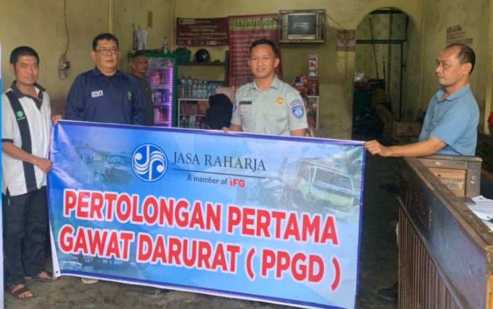 Petugas Jasa Raharja Wilayah Jambi bersama perwakilan masyarakat Kecamatan Alam Barajo, Kota Jambi, membentangkan spanduk kegiatan Pelatihan Pertolongan Pertama Gawat Darurat (PPGD), Senin (19/5/2025). . (Foto: Daus - JT)