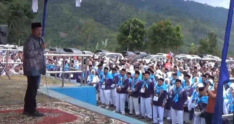 Bupati Kerinci Monadi menyampaikan sambutan dan doa saat melepas 291 calon jemaah haji Kloter 18 asal Kabupaten Kerinci di Lapangan Kantor Bupati Bukit Tengah, Siulak, Minggu (18/5/2025).
(Foto: Dok. Pemkab Kerinci)