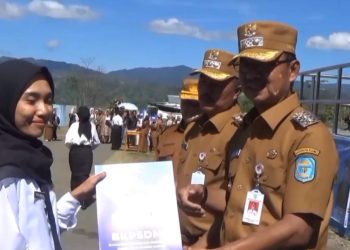 Bupati Kerinci Monadi (kanan) menyerahkan SK CPNS kepada salah satu peserta penerima di Lapangan Perkantoran Bukit Tengah, Siulak, Senin (19/5). (Dok .Yol)