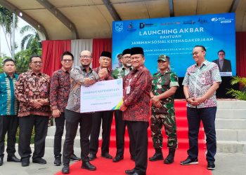 Wali Kota Jambi Dr. H. Maulana, MKM secara simbolis menyerahkan kartu kepesertaan BPJS Ketenagakerjaan kepada perwakilan pekerja rentan dalam acara Launching Akbar Bantuan Jaminan Sosial Ketenagakerjaan, di Lapangan Kantor Wali Kota Jambi, Kamis (22/5) (dok, yola -jt)