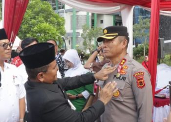 Wali Kota Jambi, Dr. dr. H. Maulana, MKM, menyematkan medali penghargaan PMI kepada AKBP Dr. Dadang Djoko Karyanto dalam peringatan Hari Donor Darah Sedunia di Lapangan Kantor Wali Kota Jambi, Senin (16/6/2025). (Dok. Daus)