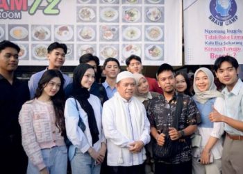 Pemilik Kopi Tiam 72, Asnawi (berkopiah putih), berfoto bersama komunitas muda dan tamu undangan usai peresmian kafe di kawasan Simpang Empat Asrama Haji, Kota Jambi, Sabtu (15/6/2025). (Dok. Nahar)