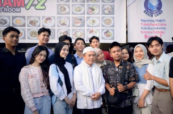 Pemilik Kopi Tiam 72, Asnawi (berkopiah putih), berfoto bersama komunitas muda dan tamu undangan usai peresmian kafe di kawasan Simpang Empat Asrama Haji, Kota Jambi, Sabtu (15/6/2025). (Dok. Nahar)
