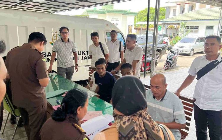 Petugas Subdit Tipidter Polda Jambi menyerahkan tiga tersangka kasus eksploitasi migas ilegal ke Kejaksaan Negeri Jambi, Rabu (18/6/2025). (Dok. Nahar)
