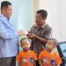 Ketua DPRD Kota Jambi, Kemas Faried Alfarelly, menyerahkan secara simbolis kartu BPJS Ketenagakerjaan kepada ayah Raffi Akbar, siswa penyintas penyakit langka Steven Johnson, didampingi anak-anaknya, Rabu (18/6/2025) di Kantor DPRD Kota Jambi. (Dk. Stepanus)