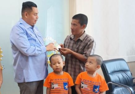 Ketua DPRD Kota Jambi, Kemas Faried Alfarelly, menyerahkan secara simbolis kartu BPJS Ketenagakerjaan kepada ayah Raffi Akbar, siswa penyintas penyakit langka Steven Johnson, didampingi anak-anaknya, Rabu (18/6/2025) di Kantor DPRD Kota Jambi. (Dk. Stepanus)