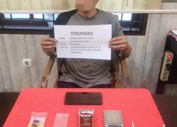 Tersangka kasus narkoba berinisial AR beserta barang bukti yang diamankan dalam penggerebekan di Paal V, Kota Jambi, Rabu (11/6/2025). (Foto: Humas Polresta Jambi)