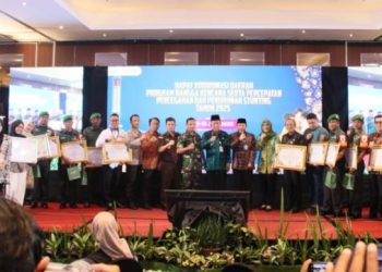 Perwakilan BKKBN Provinsi Jambi memberikan penghargaan kepada Serda Rudi Hartono dalam Rakorda Program Bangga Kencana dan Percepatan Penurunan Stunting Tahun 2025 di Hotel Aston Jambi, Jumat (20/6/2025). (Foto: Humas Kodim 0416/Bute)