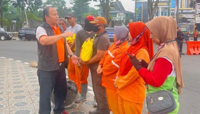 Dirintelkam Polda Jambi Kombes Pol Hendri Siregar membaur dan menyerahkan bantuan sembako kepada petugas kebersihan saat Car Free Day dan Jalan Sehat Bahagia di Tugu Keris Siginjai, Kota Jambi, Minggu (22/6/2025). (Dok. Nahar)