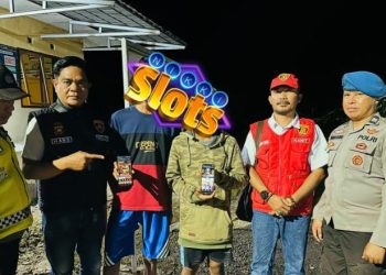 Kapolsek Berbak, Ipda Hans Simangunsong, bersama Kanit Reskrim, Kanit Binmas, dan Kanit Provost menunjukkan bukti ponsel milik dua remaja yang tertangkap sedang bermain judi online jenis slot di sebuah warung, Sabtu malam (21/6/2025). (Dok. Polsek Berbak)