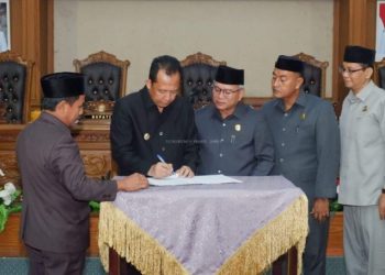 Bupati Muaro Jambi, Bambang Bayu Suseno, menyaksikan penandatanganan pengesahan tujuh Ranperda bersama jajaran DPRD dalam sidang paripurna di ruang utama DPRD Muaro Jambi, Selasa (6/5/2025). (Dok. Kominfo)