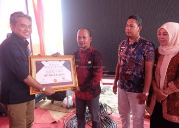 Wakil Bupati Muaro Jambi, Junaidi H. Mahir, menyerahkan secara simbolis piagam penghargaan dan dana bantuan kepada perwakilan desa bebas karhutla di area PT Brahma Bina Bakti, Kecamatan Sekernan, Kamis (5/6/2025). (Dok. Kominfo)