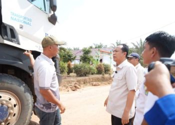 Bupati Muaro Jambi, Bambang Bayu Suseno, berdialog dengan sopir truk saat meninjau kondisi ruas jalan utama di Kecamatan Sungai Gelam, Kamis (12/6/2025). (Dok. Kominfo)