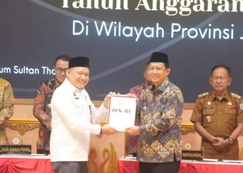Bupati Muaro Jambi menerima Laporan Hasil Pemeriksaan LKPD Tahun Anggaran 2024 dari Kepala BPK RI Perwakilan Provinsi Jambi dalam acara penyerahan opini WTP, Senin (16/6/2025). (Dok. Kominfo)