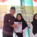 Wakil Bupati Muaro Jambi Junaidi H. Mahir menyerahkan penghargaan kepada siswa Madrasah Darul Amal dalam acara pelepasan siswa di Desa Suko Awin Jaya, Sabtu (21/6/2025). (Dok. Kominfo)