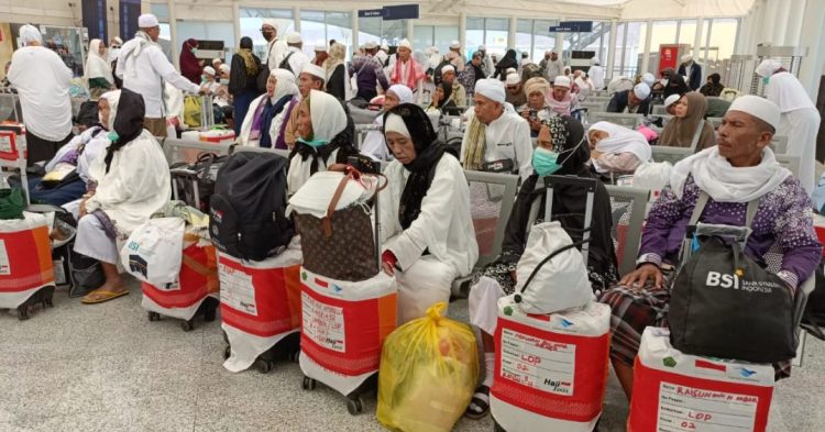 Jamaah haji Indonesia menunggu jadwal keberangkatan di terminal Bandara Arab Saudi dengan koper beridentitas kloter. Mayoritas di antaranya merupakan perempuan dan lansia. (Makkah, 2025). (Dok. mui.or.id)
