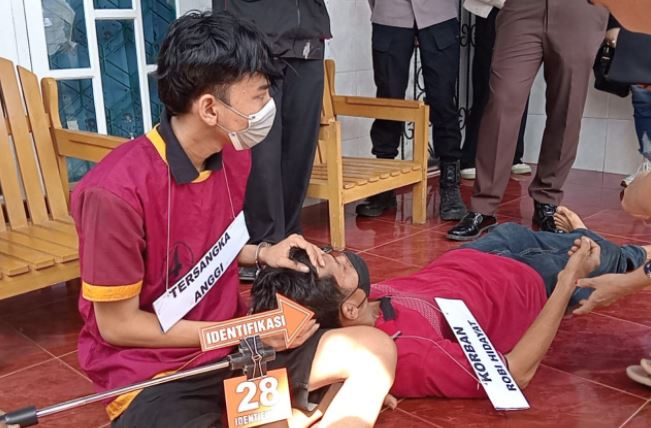 Tersangka AFY memperagakan salah satu adegan saat rekonstruksi kasus pembunuhan berencana terhadap korban RH di kosan kawasan Payo Lebar, Jambi, Senin (30/6/2026). (Dok. Nahar)