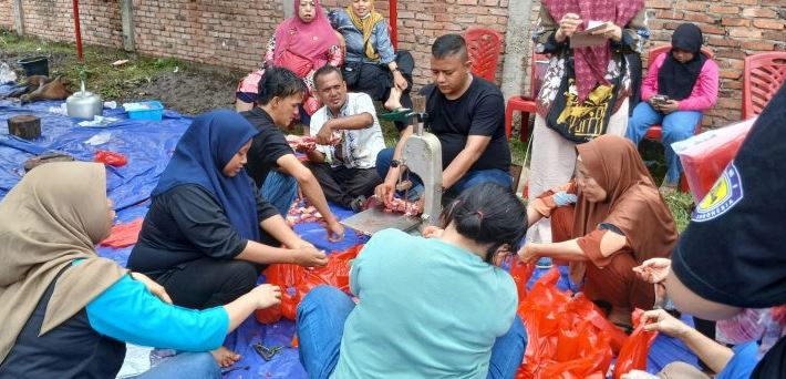 Warga dan relawan tim Misoan Diva dan Catering Diva bersama-sama mengemas daging kurban dalam kegiatan distribusi 1.000 paket daging di Kelurahan Kebun Handil, Kecamatan Jelutung, Kota Jambi, Jumat (6/6/2025). (Foto: Yola)