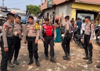Anggota Polda Metro Jaya berjaga di lokasi kebakaran di Kampung Rawa Indah, Kapuk Muara, Penjaringan, Jakarta Utara, untuk mengawal distribusi bantuan dan menjaga keamanan, Sabtu (7/6/2025). (Foto:
Mediahub.polri.go.id)