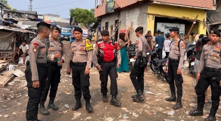 Anggota Polda Metro Jaya berjaga di lokasi kebakaran di Kampung Rawa Indah, Kapuk Muara, Penjaringan, Jakarta Utara, untuk mengawal distribusi bantuan dan menjaga keamanan, Sabtu (7/6/2025). (Foto:
Mediahub.polri.go.id)