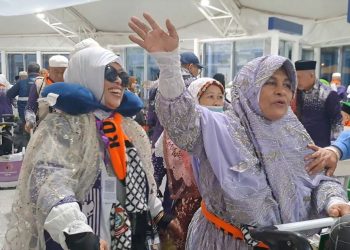 Jamaah haji Indonesia dari kloter UPG 1 Makassar melambaikan tangan sebelum diberangkatkan dari Bandara AMAA, Madinah, Rabu (11/6/2025), (Dok. mui.or.id)