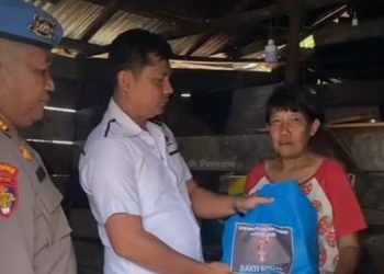 Personel Sipropam Polresta Jambi menyerahkan bantuan sembako secara langsung kepada warga dalam kegiatan bakti sosial memperingati HUT Bhayangkara ke-79 di Kecamatan Telanaipura, Rabu (11/6/2025). (Foto: Stepanus)