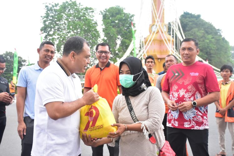 Wakapolda Jambi, Brigjen Pol Mirza Mustaqim menyerahkan sembako kepada warga pada kegiatan kegiatan CFD di Tugu Keris Siginjai,Kota Jambi Minggu (22/6/2025).(Dok. Nahar)