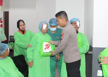 Seorang pasien penerima operasi katarak menerima paket bantuan dari anggota Polda Jambi di RS Bhayangkara, Rabu (11/6/2025). (Dok. Daus)