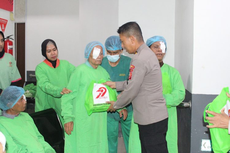Seorang pasien penerima operasi katarak menerima paket bantuan dari anggota Polda Jambi di RS Bhayangkara, Rabu (11/6/2025). (Dok. Daus)