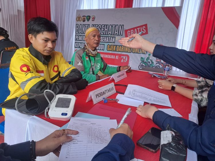Petugas medis memeriksa kondisi kesehatan pengemudi ojek online dalam kegiatan bakti kesehatan Polda Jambi di RS Bhayangkara, Kamis (12/6/2025). (Dok. Daus)