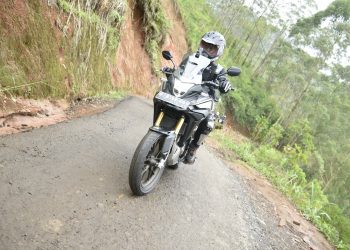 Seorang pengendara motor melintasi jalan sempit dan rusak di kawasan perbukitan. (Foto: Dok. Sinsen)