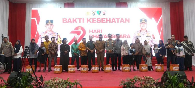 Kapolda Jambi Irjen Pol. Krisno Halomoan Siregar, Danrem 042/Gapu Brigjen TNI Heri Purwanto, dan para pejabat daerah berfoto bersama peserta usai kegiatan Bakti Kesehatan dalam rangka Hari Bhayangkara ke-79 di Gedung Putih Grand Kemas, Jambi, Senin (16/6/2025). (Dok. Nahar)