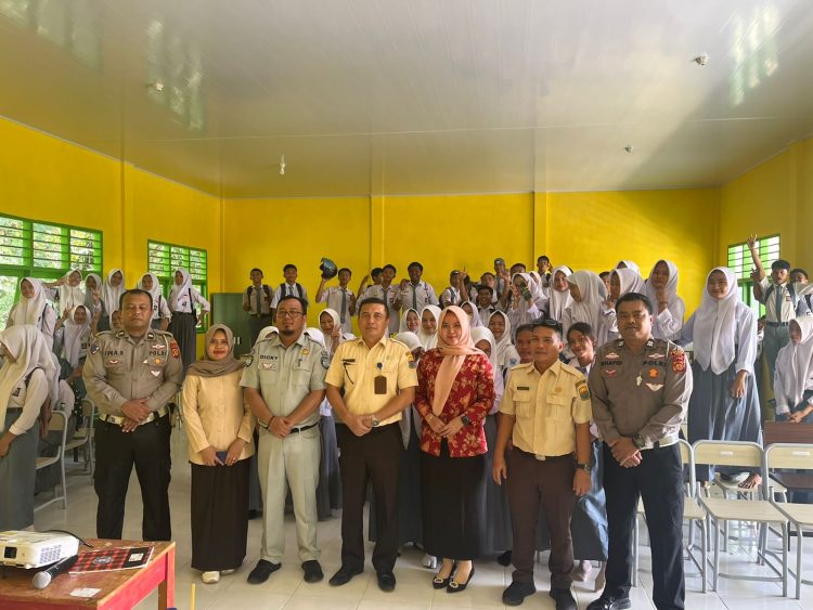 Petugas Jasa Raharja Samsat Muara Tebo, Kepolisian, dan Kepala Samsat Tebo berfoto bersama guru serta siswa-siswi SMKN 8 Tebo usai menggelar sosialisasi keselamatan lalu lintas dan edukasi administrasi kendaraan bermotor, Senin (16/6/2025). (Dok. Humas JR Jambi)