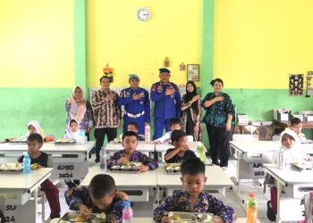 Anggota Ditpolairud Polda Jambi bersama guru dan siswa SDN 73/IV Cempaka Putih saat pelaksanaan Program Makan Bergizi Gratis (MBG), Kamis (24/7/2025). (Dok. Stepanus)