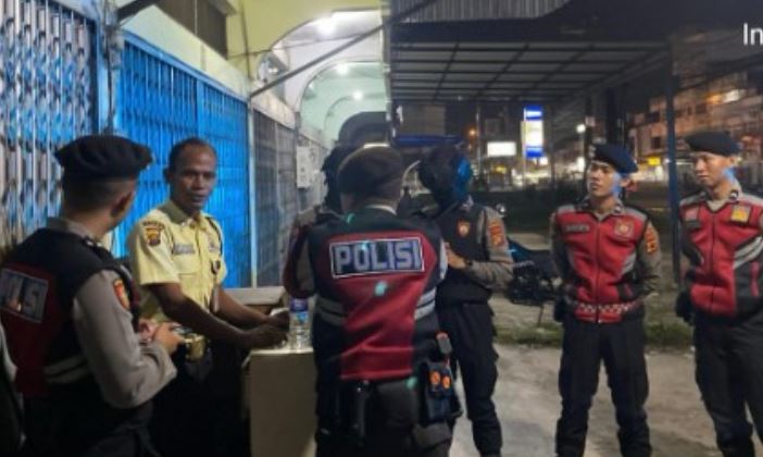 Personel Dit Samapta Polda Jambi berdialog dengan petugas keamanan Pegadaian Syariah Talang Banjar saat melaksanakan patroli dialogis guna menjaga situasi kamtibmas tetap kondusif, Sabtu (12/7/2025) malam. (Dok Daus)