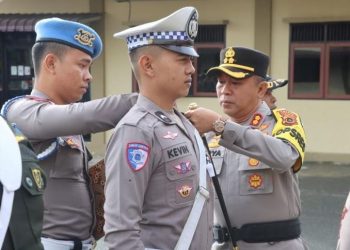 Kapolres Kerinci AKBP Arya Tesa Brahmana, S.I.K., M.H. menyematkan pita tanda dimulainya Operasi Patuh Siginjai 2025 kepada anggota satuan lalu lintas saat Apel Gelar Pasukan di Mapolres Kerinci, Senin (14/7/2025). (Dok. Humas)