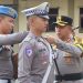 Kapolres Kerinci AKBP Arya Tesa Brahmana, S.I.K., M.H. menyematkan pita tanda dimulainya Operasi Patuh Siginjai 2025 kepada anggota satuan lalu lintas saat Apel Gelar Pasukan di Mapolres Kerinci, Senin (14/7/2025). (Dok. Humas)
