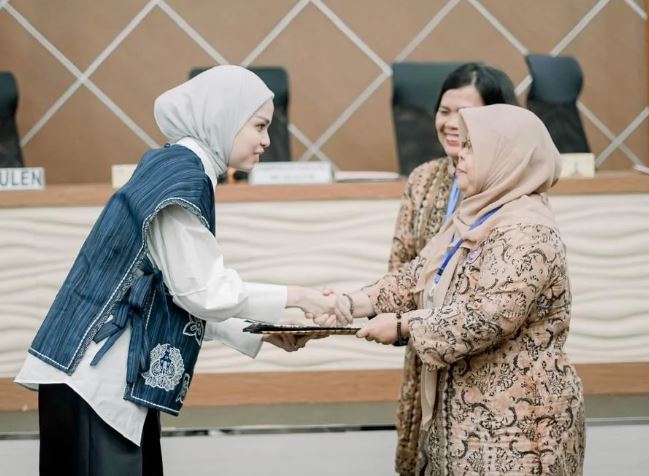 Marsha Lystia (kiri) bersalaman dengan Ketua GOW demisioner Dr. dr. Hj. Nadiyah Maulana, Sp.OG., usai terpilih secara aklamasi sebagai Ketua GOW Kota Jambi periode 2025–2030 dalam Musdalub yang digelar di Aula PKK Kota Jambi, Senin (14/7/2025). (Dok. Yola)