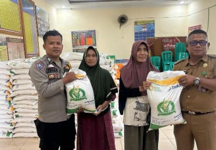 Bhabinkamtibmas Polsek Jambi Selatan dan Lurah Lingkar Selatan menyerahkan secara simbolis bantuan beras kepada warga penerima manfaat di Aula Kantor Lurah, Senin (14/7/2025). (Dok. Daus)