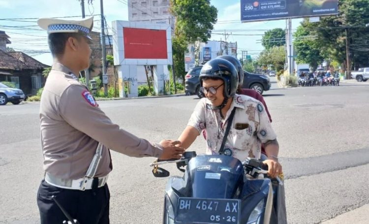 Petugas Satlantas Polresta Jambi memberikan teguran kepada pengendara motor yang tidak membawa kelengkapan berkendara saat razia di Simpang Traffic Light Jelutung, Kota Jambi, Selasa (16/7/2025). (Dok. Stepanus)