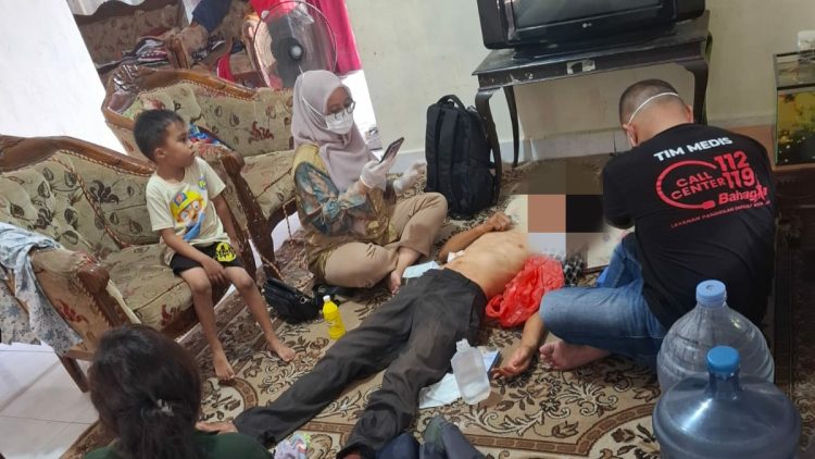 Petugas medis dari Dinas Sosial Kota Jambi memberikan pertolongan kepada ODGJ bernama Aladin yang ditemukan dalam kondisi terluka di Lorong Saung Kito, Kelurahan Solok Sipin, Kota Jambi, Kamis (24/7/2025). (Foto : Stepanus)