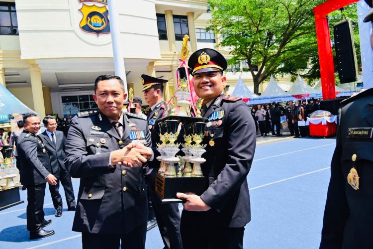 Kapolsek Jaluko, Iptu Yohanes Chandra, menerima piala penghargaan usai meraih juara dalam ajang Lomba Inovasi Ketahanan Pangan Polda Jambi 2025 pada acara Syukuran Hari Bhayangkara Ke-79 Tahun 2025 di Lapangan Mapolda Jambi, Selasa (1/7/2025). (Foto: Nahar)