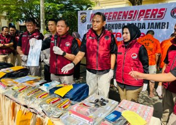 Direktur Resnarkoba Polda Jambi Kombes Pol Ernesto Saiser menunjukkan barang bukti sabu, ekstasi, uang tunai, serta dokumen transaksi dalam konferensi pers pengungkapan kasus narkotika dan pencucian uang jaringan Fredy Pratama di Mapolda Jambi, Kamis (3/7/2025). (Dok. Nahar)