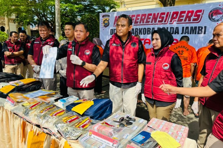 Direktur Resnarkoba Polda Jambi Kombes Pol Ernesto Saiser menunjukkan barang bukti sabu, ekstasi, uang tunai, serta dokumen transaksi dalam konferensi pers pengungkapan kasus narkotika dan pencucian uang jaringan Fredy Pratama di Mapolda Jambi, Kamis (3/7/2025). (Dok. Nahar)