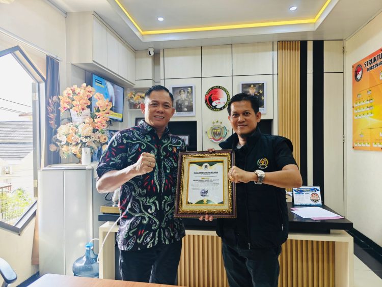 Ketua Persatuan Wartawan Indonesia (PWI) Kota Jambi Irwansyah memberikan penghargaan kepada Dirresnarkoba Polda Jambi Kombes Pol Dr Ernesto Saiser, di ruang kerjanya, Jum’at (04/7/2025). (Dok. Nahar)
