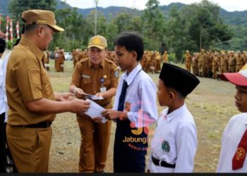 Bupati Kerinci Monadi menyerahkan secara simbolis bantuan pendidikan dari Program Kerinci Cerdas kepada siswa yatim dan terlantar usai apel pagi di halaman Kantor Bupati Kerinci, Senin (7/7/2025). (Dok. Yola)