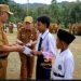 Bupati Kerinci Monadi menyerahkan secara simbolis bantuan pendidikan dari Program Kerinci Cerdas kepada siswa yatim dan terlantar usai apel pagi di halaman Kantor Bupati Kerinci, Senin (7/7/2025). (Dok. Yola)