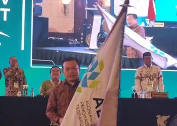 Gubernur Jambi Al Haris menerima bendera pataka ADPMET usai terpilih sebagai Ketua Umum dalam Munas V Asosiasi Daerah Penghasil Migas dan Energi Terbarukan di Jakarta, Kamis (10/07/2025). (Dok. Erit - Kominfo)